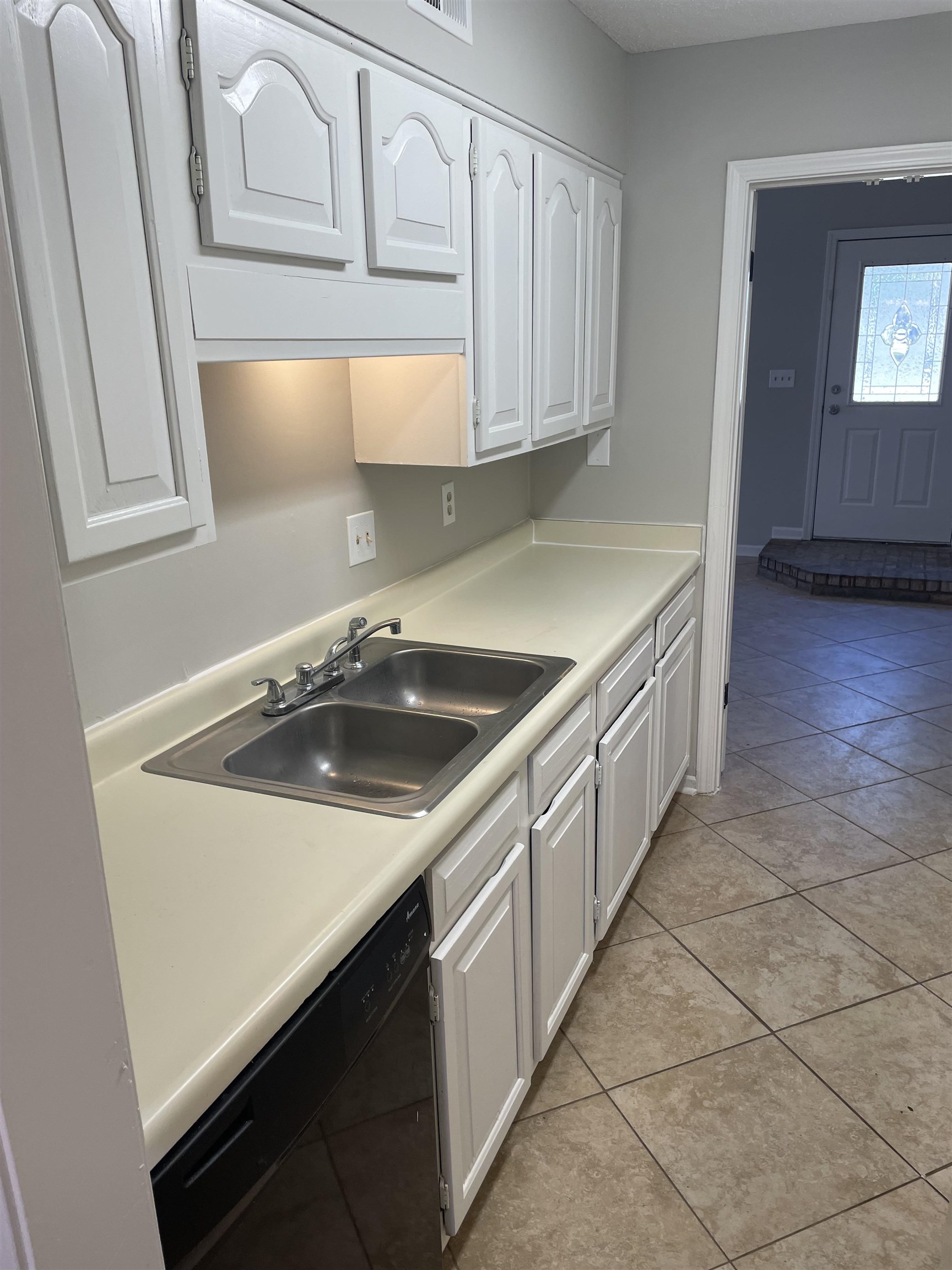242 South Walnut Bend Road Memphis, TN 38018 - Photo 7 of 17 Kitchen with white cabinets, light tile patterned floors, dishwasher, and sink