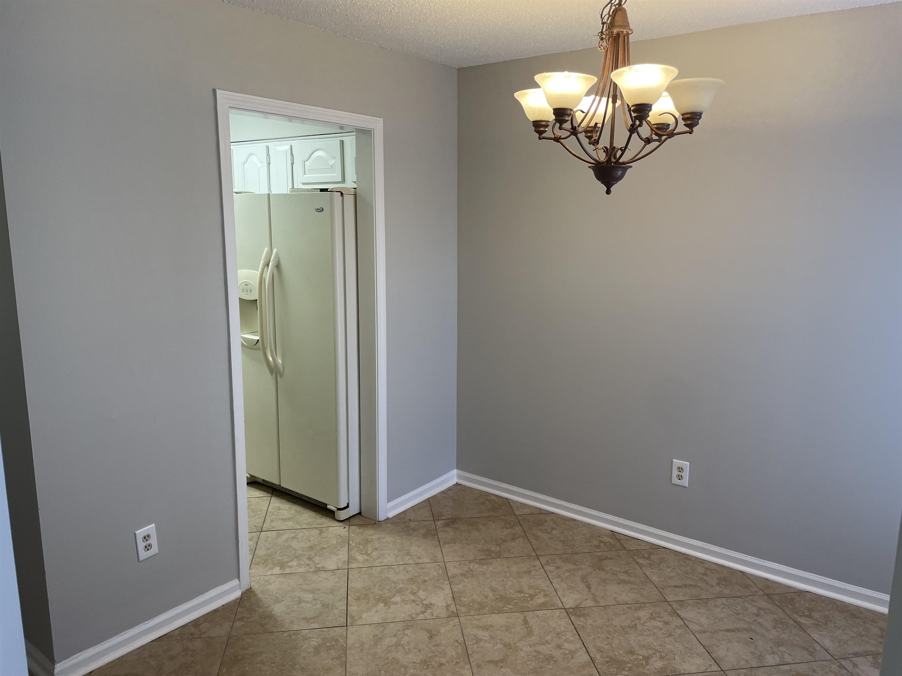 242 South Walnut Bend Road Memphis, TN 38018 - Photo 8 of 17 Tiled spare room with a notable chandelier and a textured ceiling