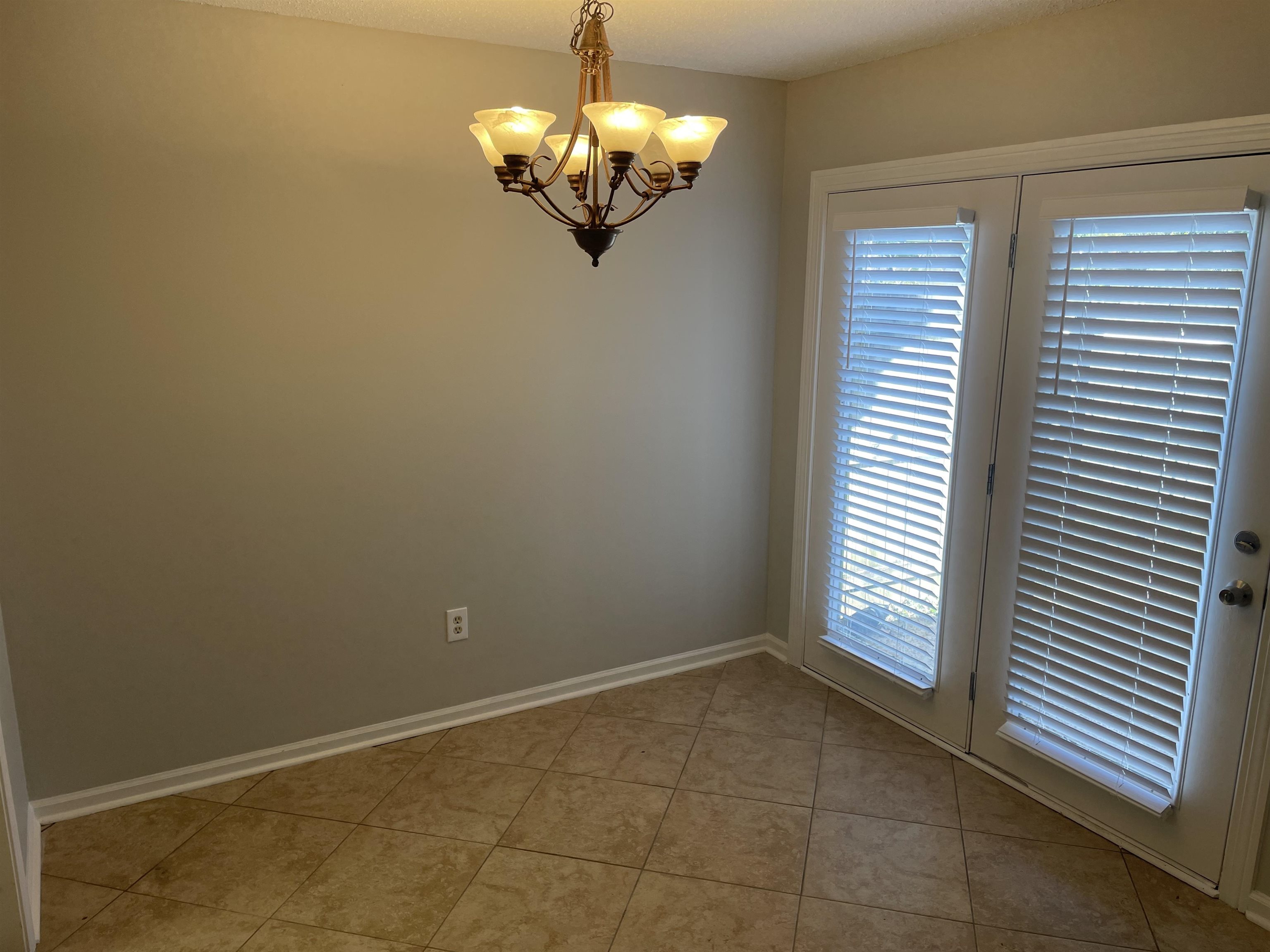 242 South Walnut Bend Road Memphis, TN 38018 - Photo 9 of 17 Unfurnished room featuring light tile patterned floors and a chandelier