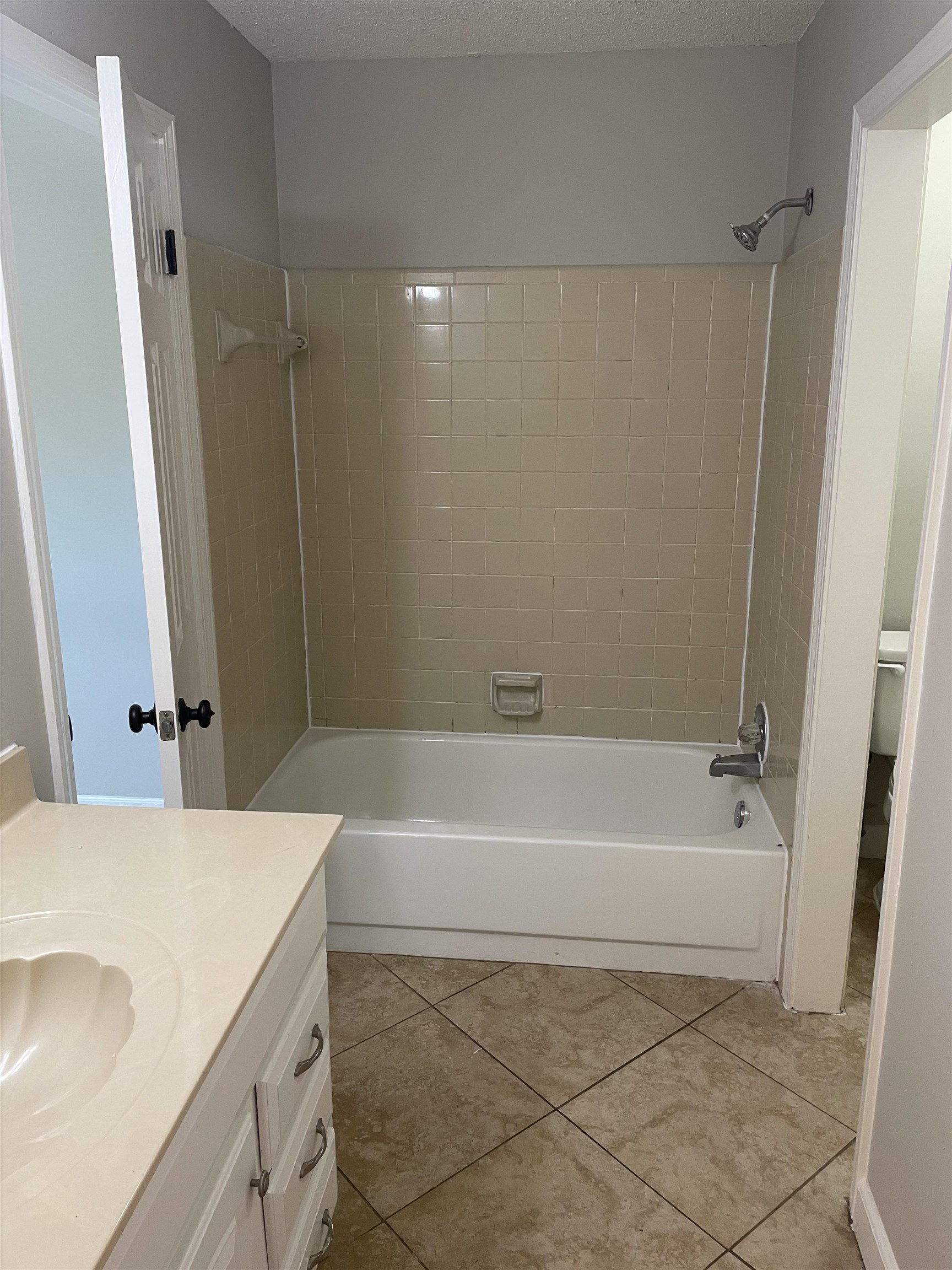 242 South Walnut Bend Road Memphis, TN 38018 - Photo 10 of 17 Bathroom featuring tile patterned flooring, a textured ceiling, and tiled shower / bath