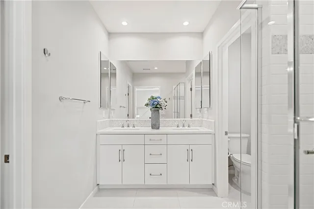 a bathroom with a sink a toilet and a large mirror