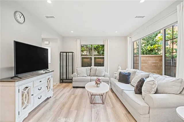 a living room with furniture a flat screen tv and a floor to ceiling window