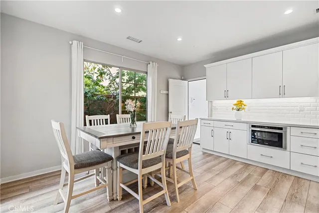 a kitchen with a stove a table and chairs in it