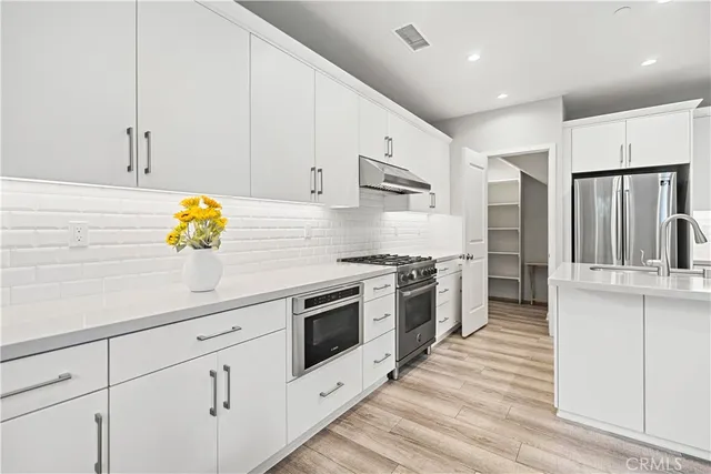 a kitchen with stainless steel appliances white cabinets sink and stainless steel appliances