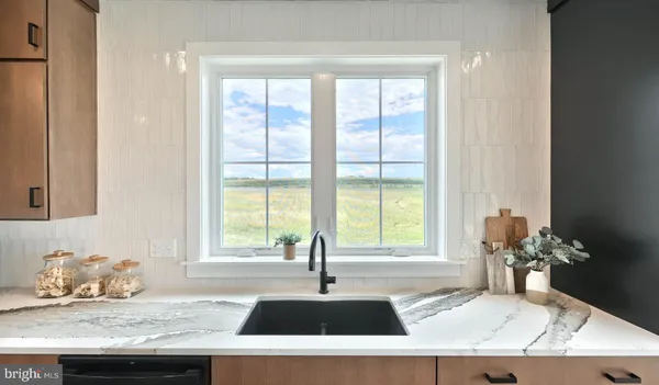 a kitchen with granite countertop a sink and a white wooden cabinets