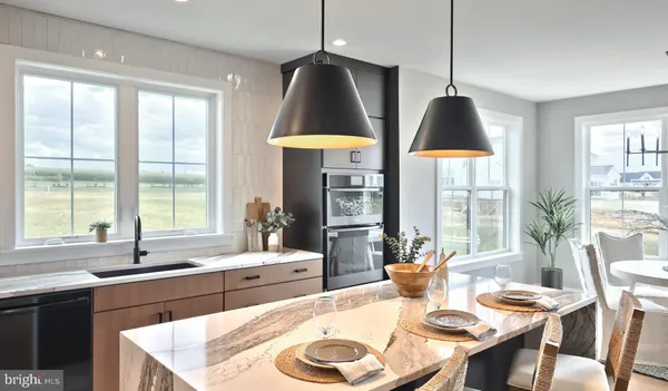 a kitchen with a stove a sink a dining table and chairs