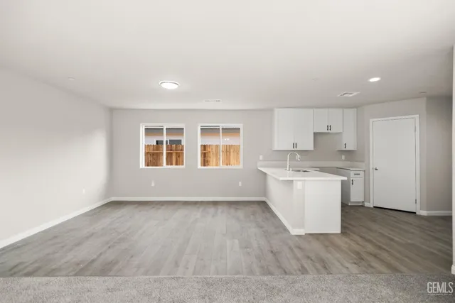 an empty room with windows and ceiling fan