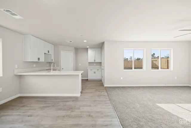 a view of kitchen with granite countertop cabinets and sink