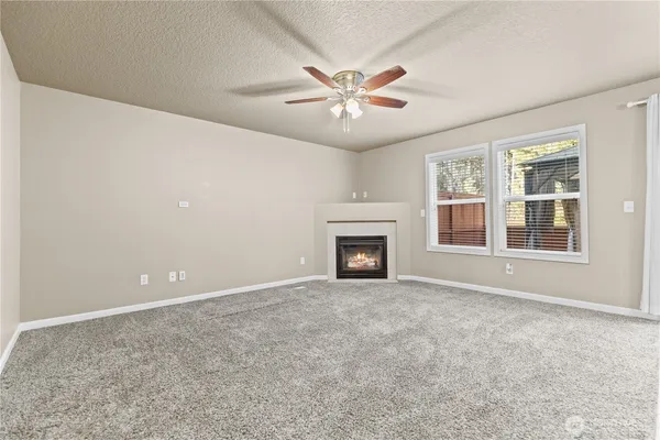 an empty room with windows and fireplace