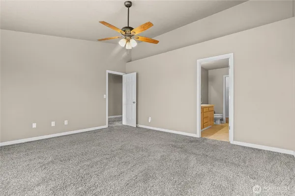 a view of an empty room with a chandelier fan