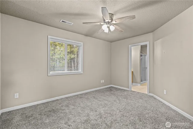 a view of an empty room with a chandelier fan