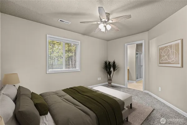 a bedroom with a large bed and a chandelier
