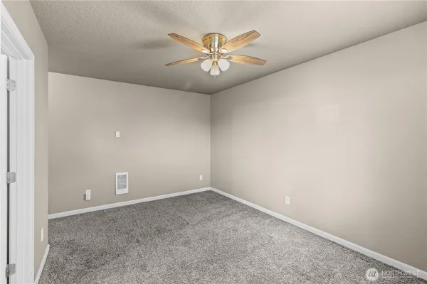 an empty room with a ceiling fan and a window
