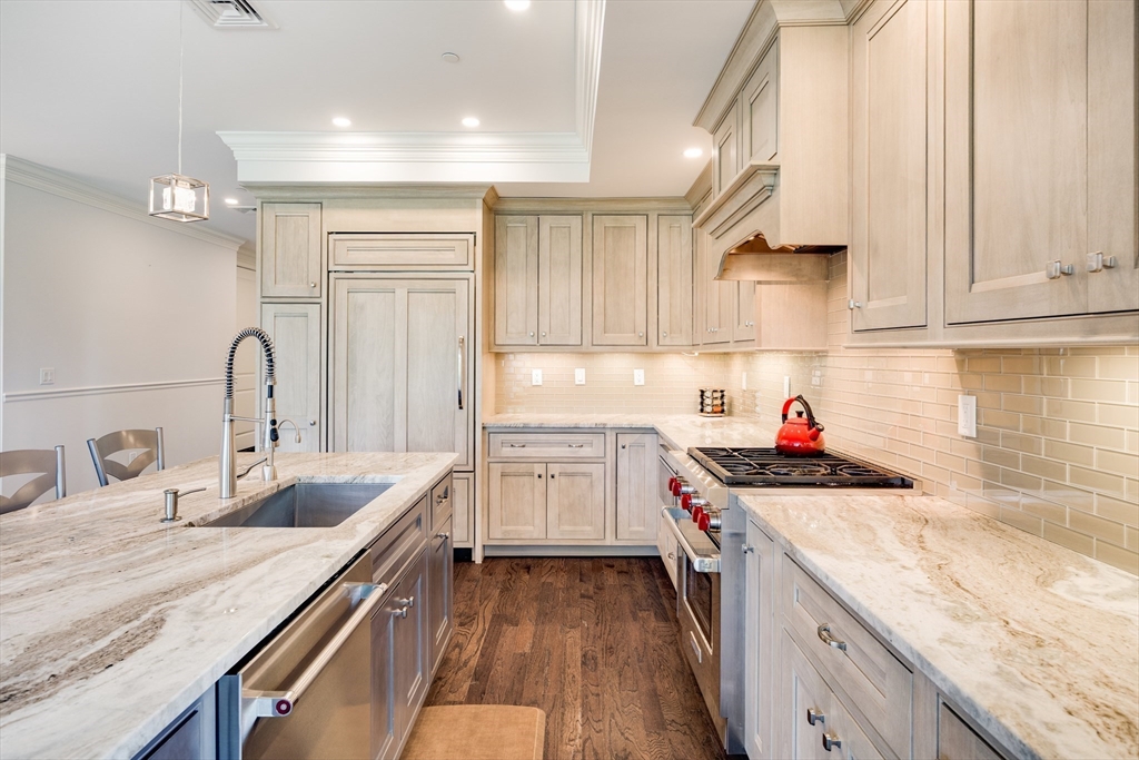 66 Simons Road, Unit C Mashpee, MA 02649 - Photo 11 of 42 a kitchen with granite countertop a sink stove and cabinets