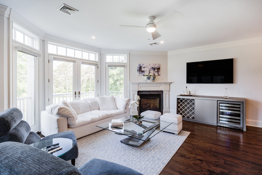 66 Simons Road, Unit C Mashpee, MA 02649 - Photo 14 of 42 a living room with furniture a fireplace and a flat screen tv