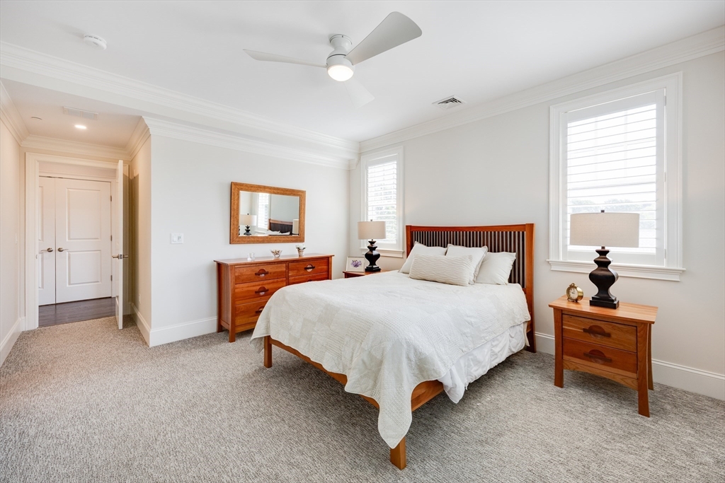 66 Simons Road, Unit C Mashpee, MA 02649 - Photo 25 of 42 a spacious bedroom with a bed and a cabinets