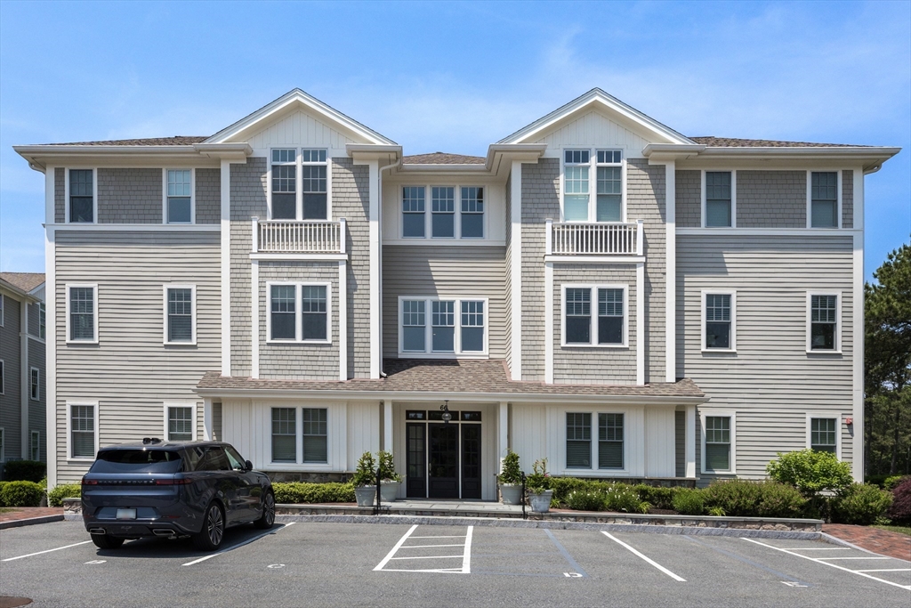 66 Simons Road, Unit C Mashpee, MA 02649 - Photo 3 of 42 a front view of a building with cars parked