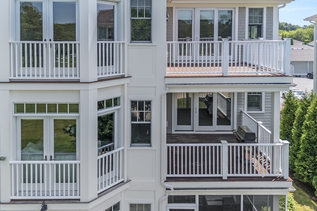 66 Simons Road, Unit C Mashpee, MA 02649 - Photo 31 of 42 a view of a brick house with large windows