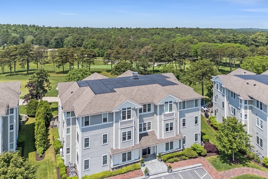 66 Simons Road, Unit C Mashpee, MA 02649 - Photo 32 of 42 an aerial view of residential houses with outdoor space and trees