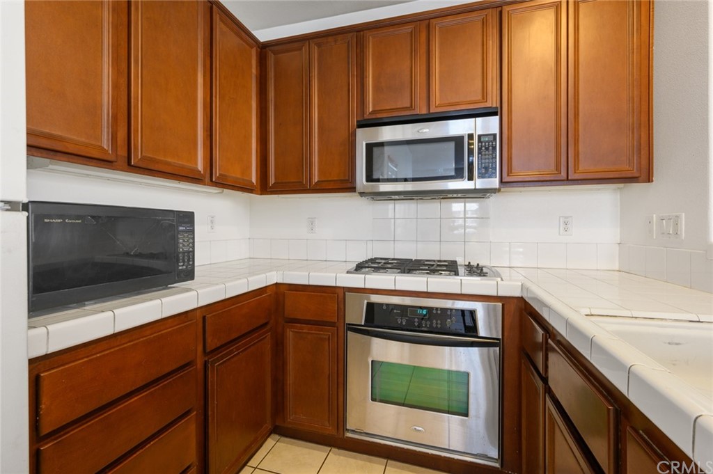 106 Tiger Lane Placentia, CA 92870 - Photo 11 of 35 a kitchen with stainless steel appliances granite countertop a stove microwave and sink