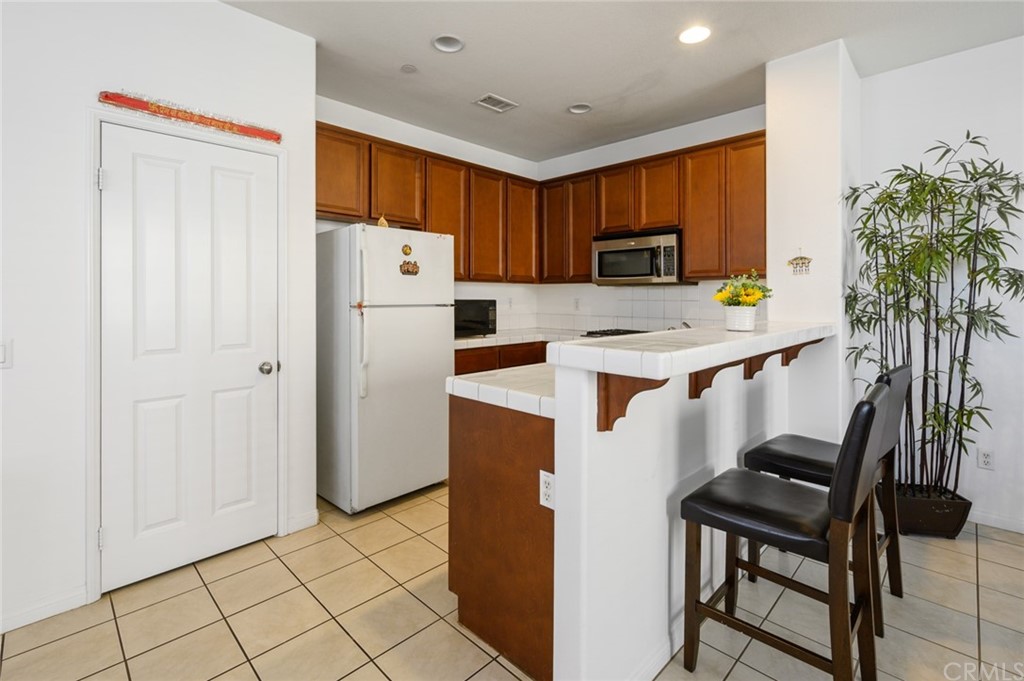 106 Tiger Lane Placentia, CA 92870 - Photo 9 of 35 a kitchen with stainless steel appliances granite countertop a refrigerator and a stove top oven