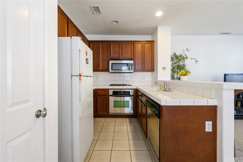 106 Tiger Lane Placentia, CA 92870 - Photo 10 of 35 a kitchen with stainless steel appliances granite countertop a stove a sink and a refrigerator