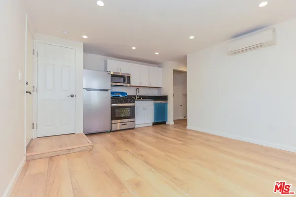 a view of a kitchen with a sink and a refrigerator