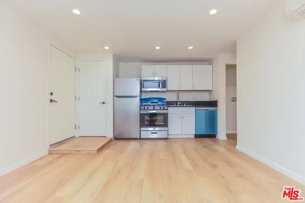 a kitchen with stainless steel appliances granite countertop a refrigerator and a stove top oven