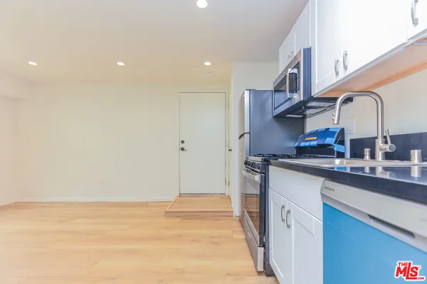 a kitchen with stainless steel appliances granite countertop a sink and cabinets