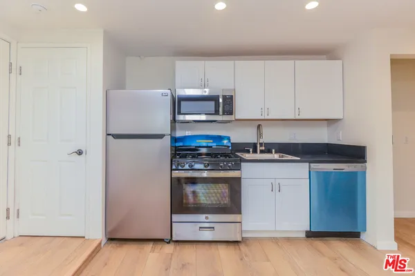 a kitchen with stainless steel appliances granite countertop a stove a refrigerator and a sink