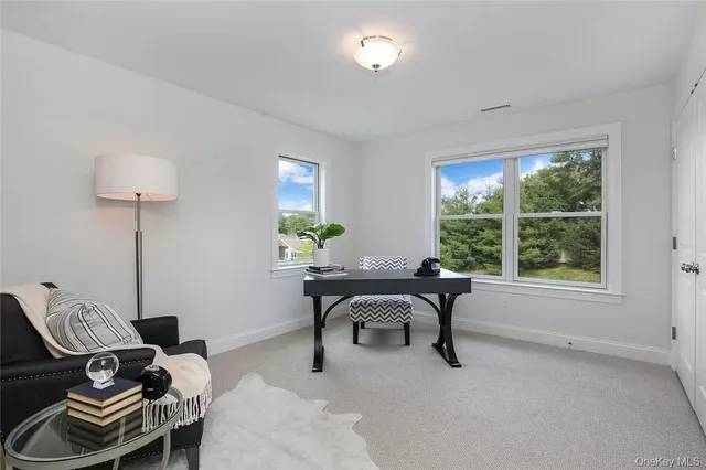 a view of a workspace with furniture and a window