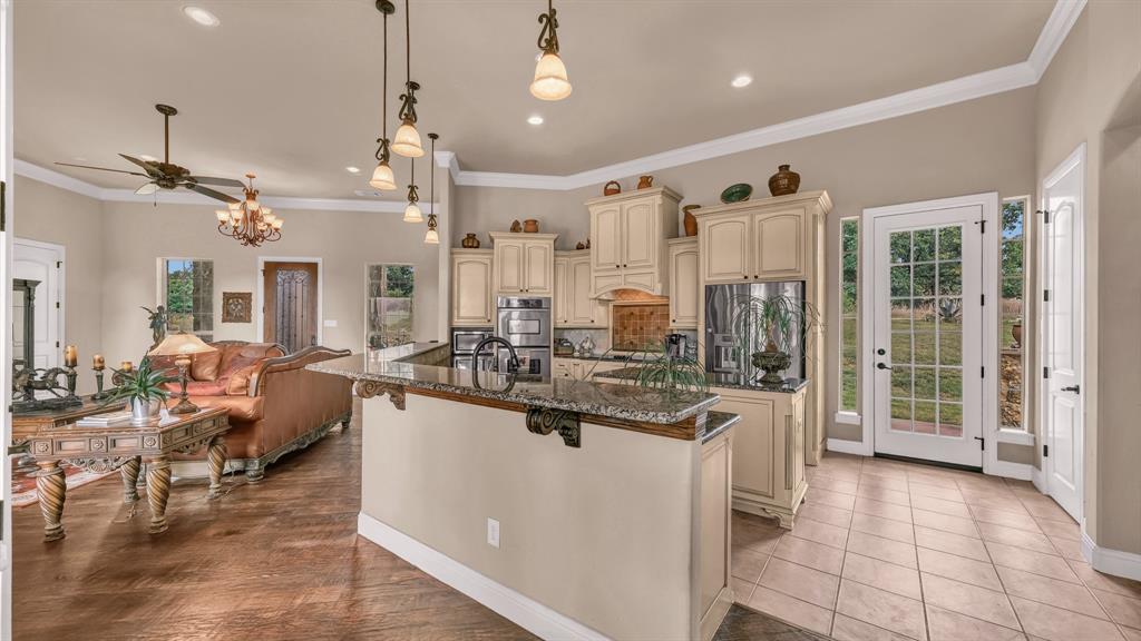 840 Hensley Road Gordon, TX 76453 - Photo 12 of 40 Kitchen with a center island with sink, dark stone counters, stainless steel appliances, recessed lighting, and cream cabinetry