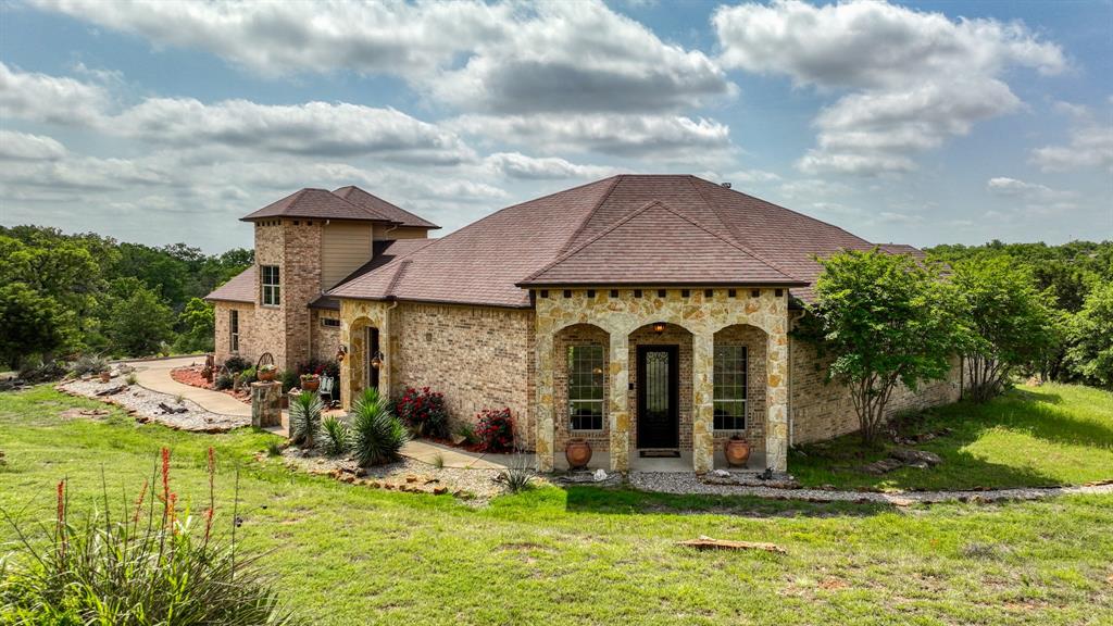 840 Hensley Road Gordon, TX 76453 - Photo 2 of 40 View of front of property featuring a shingled roof, stone siding, and a front lawn
