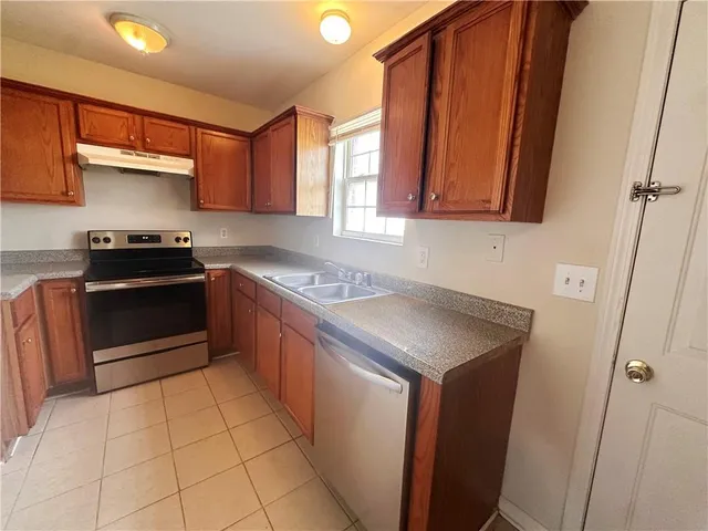 a kitchen with stainless steel appliances a sink stove and cabinets
