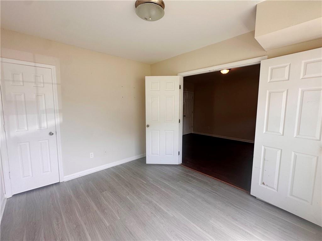 838 Store House Court, Unit A Monroe, GA 30655 - Photo 6 of 22 a view of an empty room with wooden floor and closet