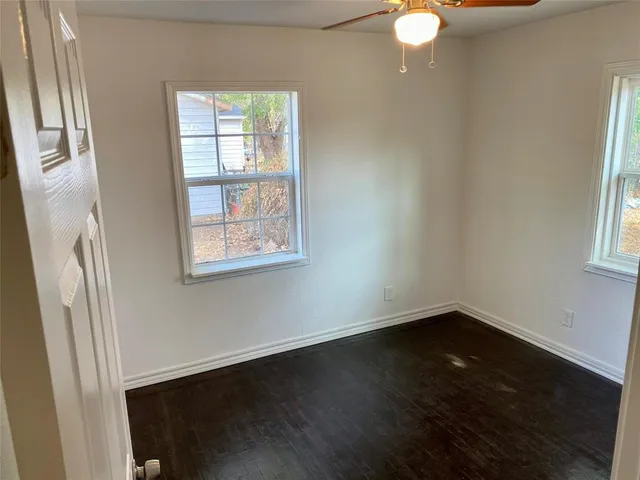 an empty room with a fireplace and fan