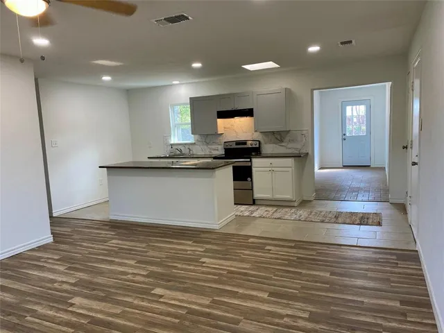 a kitchen with stainless steel appliances granite countertop a sink and a stove