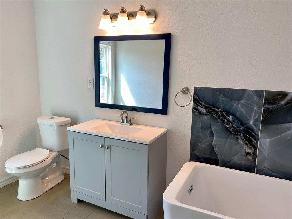 100 Burl Street Corinth, TX 76208 - Photo 3 of 16 a bathroom with a sink toilet and mirror