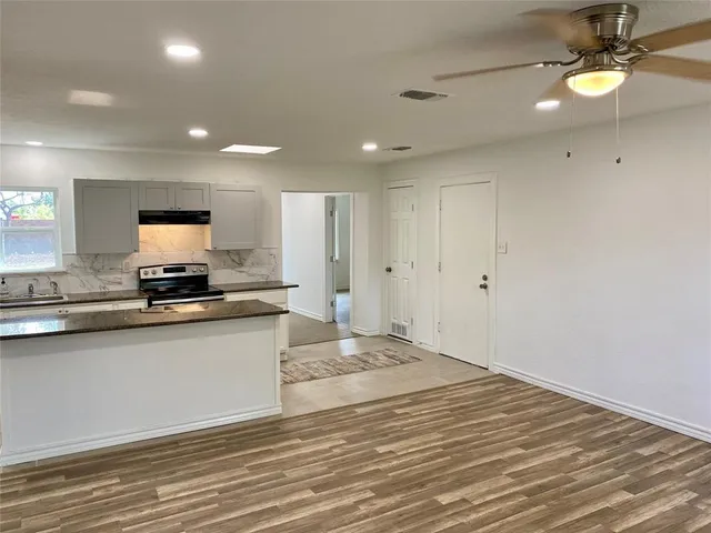 a view of a kitchen with a sink and a refrigerator