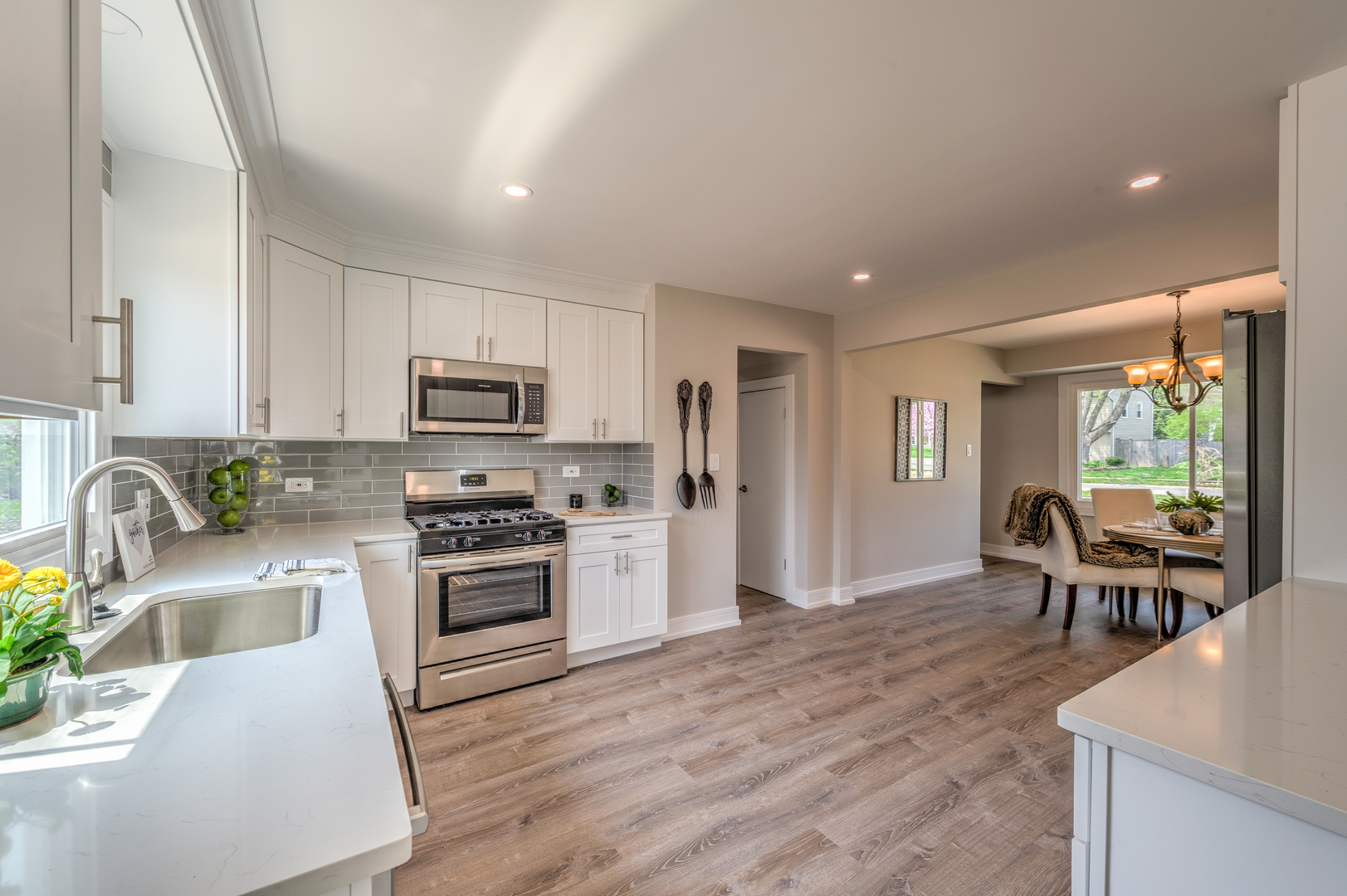 178 Queenswood Road Bolingbrook, IL 60440 - Photo 10 of 26 a kitchen with stainless steel appliances granite countertop a stove top oven a sink a dining table and chairs with wooden floor