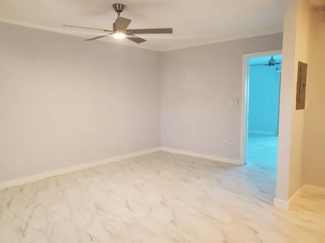 a view of a livingroom with a ceiling fan & hardwood floor