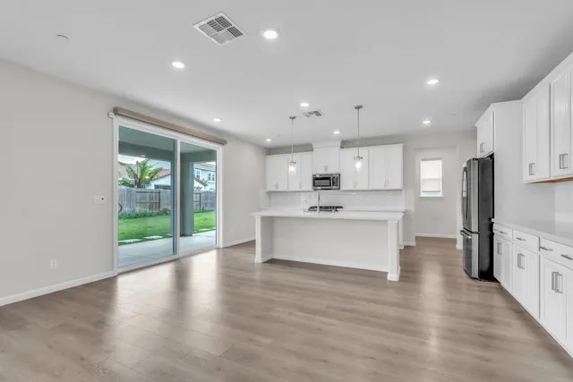 a kitchen with granite countertop white cabinets and stainless steel appliances