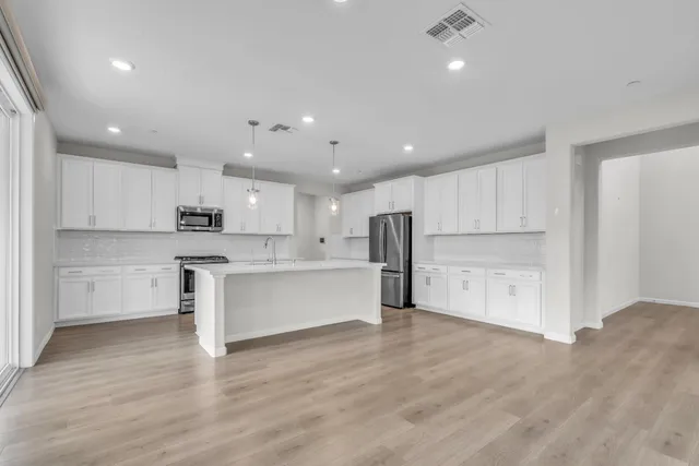 a kitchen with a sink a counter top space stainless steel appliances and cabinets