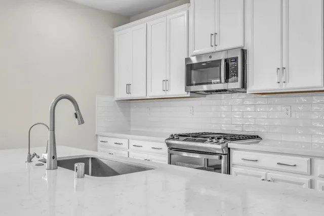 a kitchen with stainless steel appliances a refrigerator sink and cabinets