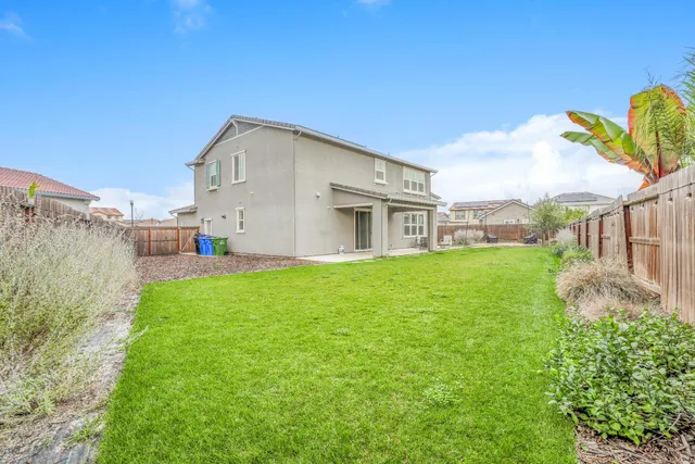 a view of a house with backyard and porch