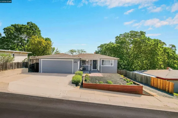 a view of a house with backyard and wooden fence