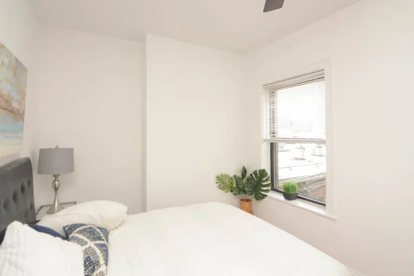 a bedroom with a bed and a window