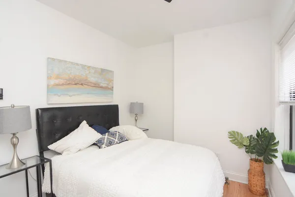 a bed room with a bed and a potted plant