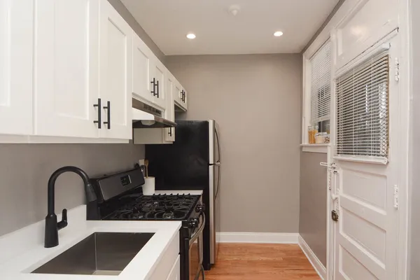 a kitchen with stainless steel appliances granite countertop a sink and a refrigerator