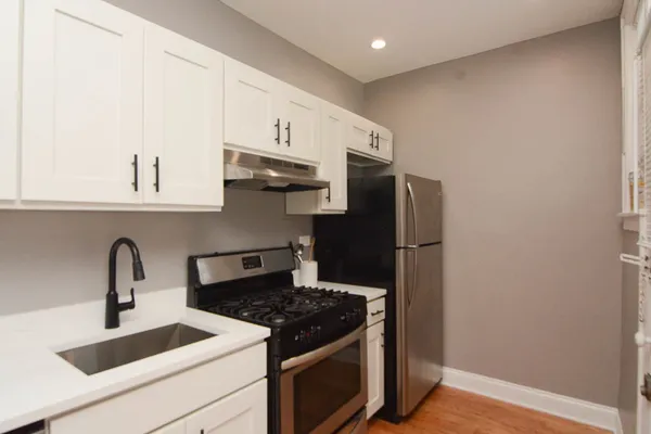 a kitchen with stainless steel appliances granite countertop a refrigerator sink and stove
